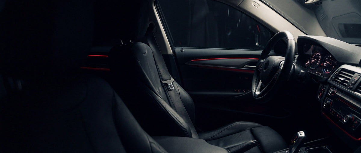 Driver seat, seatbelt and steering wheel inside a car at night